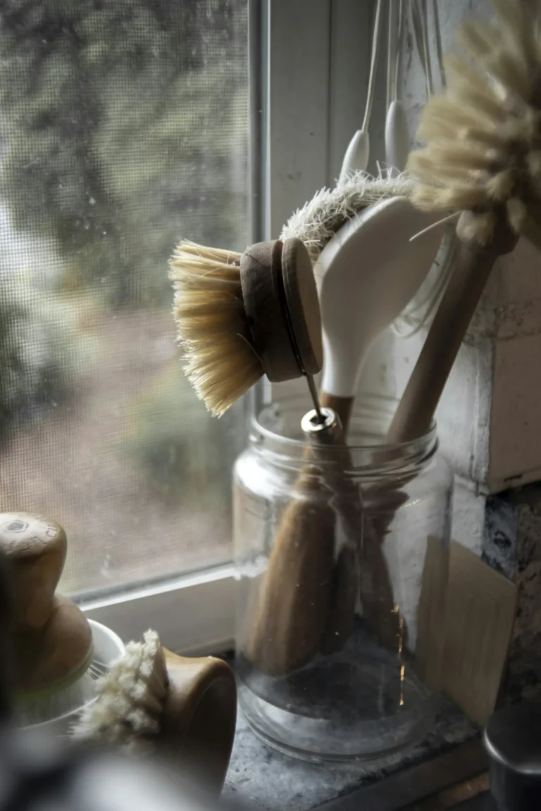 Wooden dish brush standing in a clear glass jar